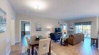 This 1327 square foot apartment at 9 Covered Bridge Road offers a harmonious blend of comfort and style. The open-concept living area seamlessly integrates the living room, dining space, and kitchen, creating an ideal environment for both relaxation and entertainment. The living room features a plush sofa, vibrant blue accent chair, and carefully curated artwork that adds a touch of sophistication.

The modern kitchen boasts white cabinetry, stainless steel appliances, and a subway tile backsplash, complemented by granite countertops and a central island. Adjacent to the kitchen, a cozy dining nook with a round table offers picturesque views through large windows.

Both bedrooms are generously sized, with the master bedroom featuring an en-suite bathroom. The bathrooms are elegantly appointed with contemporary fixtures and finishes. Throughout the apartment, hardwood floors and neutral wall colors create a bright, airy atmosphere, enhanced by strategically placed lighting fixtures.

Thoughtful details such as area rugs, decorative pillows, and well-chosen artwork contribute to the overall aesthetic appeal. The apartment's layout maximizes space efficiency while maintaining a sense of openness, making it an ideal home for modern living.