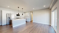 Located at 2 Towpath Rd in Halfmoon, NY, this two-story home offers a clean, modern aesthetic across two well-organized levels. The main living floor is bright and open, anchored by a contemporary kitchen that serves as the centerpiece of the space. White shaker-style cabinetry, a large center island with a quartz countertop and undermount sink, subway tile backsplash, stainless steel appliances, and bold black pendant lighting combine for a polished, functional design. Hardwood-style flooring runs throughout the main living areas, complementing the neutral gray-toned walls and crisp white trim. A sliding glass door and large windows in the living area flood the space with natural light and provide views of the surrounding neighborhood. The full bathroom features marble-look tile flooring and a dark wood vanity. Both bedrooms are well-proportioned, with the primary bedroom offering a walk-in closet equipped with wire shelving. Three closets total provide ample storage throughout. A dedicated laundry area and utility room add to the home's practicality. The attached garage includes an automatic opener and interior access. The overall ambiance is contemporary, clean, and move-in ready.