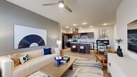 This contemporary apartment in Mishawaka, IN offers 1270 square feet of thoughtfully designed living space. The open-concept floor plan seamlessly integrates the kitchen, living, and dining areas, creating an ideal environment for both relaxation and entertainment. The gourmet kitchen boasts sleek dark wood cabinetry, stainless steel appliances, and a spacious island with seating, perfect for casual dining or meal preparation.

The two bedrooms provide ample space, with the primary bedroom measuring 150 square feet. Large windows in the bedrooms and living areas flood the space with natural light, while offering picturesque views of the surroundings. The two full bathrooms feature modern fixtures, including a combination tub-shower in at least one.

Additional amenities include an in-unit laundry room with full-sized washer and dryer, and a dedicated exercise room for convenient at-home workouts. The apartment's decor is characterized by a neutral color palette with pops of blue, creating a cohesive and stylish aesthetic throughout. Hardwood-style flooring in the main living areas and plush carpeting in the bedrooms add warmth and comfort to the space.

Storage is abundant, with two closets and additional built-in storage solutions. The apartment's modern design is complemented by contemporary artwork and furnishings, enhancing its overall appeal and livability.
