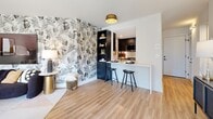 Located at 1550 N Clarendon Blvd in Arlington, VA, this well-appointed residence offers a thoughtfully designed single-floor layout. The open-concept living and dining area is bright and airy, with light wood flooring, clean white walls, and floor-to-ceiling sliding glass doors that lead to a private balcony, flooding the space with natural light and providing outdoor access. The kitchen features a galley-style configuration with dark upper cabinetry, warm wood lower cabinets, white countertops, and stainless steel LG appliances, including a French door refrigerator and gas range. The bedroom is a standout space, highlighted by bold botanical wallpaper, a dedicated closet, and its own sliding glass door access to the balcony. The bathroom is finished with dark tile walls surrounding a soaking tub and shower combination, paired with a vanity and wood-look flooring. A dedicated laundry area accommodates a full stacked Samsung washer and dryer unit. Additional features include a closet with built-in shelving and two hallway areas that connect the layout efficiently. This residence combines contemporary finishes with functional design in a prime Arlington location.