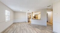 Located at 4123 Vista Verde Dr in New Port Richey, FL, this well-appointed one-bedroom, one-bathroom unit offers a thoughtfully designed single-floor layout. Light-toned wood-style flooring flows throughout the entire space, complementing the neutral warm-beige walls and textured ceilings that lend a clean, cohesive aesthetic.

The open-concept living, dining, and kitchen area serves as the heart of the home. The living and dining space is generously proportioned, bathed in natural light from multiple windows dressed with blinds, and features a sliding glass door that opens onto a private balcony with outdoor views. A subtle chair-rail detail runs along the walls, adding a classic architectural touch.

The kitchen is well-equipped with white shaker-style cabinetry, granite countertops, a white subway tile backsplash, and a full suite of stainless steel appliances including a refrigerator, electric range, over-the-range microwave, and dishwasher. A breakfast bar provides additional counter space and a casual dining option.

The bedroom is comfortably sized, featuring a ceiling fan with light, a window with natural light, and multiple closets for ample storage. The bathroom includes a full-size soaking tub and shower combination with white tile surround, maintaining the clean and bright character found throughout the home.