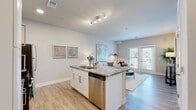 Located at 1330 Kelly Johnson Blvd in Colorado Springs, CO, this single-story residence offers a thoughtfully designed open-concept layout with modern finishes throughout. Light-toned luxury vinyl plank flooring flows seamlessly through the main living areas, complementing the neutral color palette that gives the space a bright, airy feel.

The kitchen serves as a central hub, featuring white shaker cabinetry, granite countertops, a large central island with bar seating, and a full suite of stainless steel appliances including a range, microwave, and refrigerator. Track lighting overhead ensures the space is well-illuminated. The kitchen opens directly into the living area, which benefits from natural light through large windows and French doors that lead to a private outdoor access point.

The bedroom is generously proportioned, finished with plush carpet, and includes access to a walk-in closet. A second bedroom features wide windows with views of the surrounding landscape. The bathroom continues the granite and white cabinetry theme, with wood-look flooring, a vanity, and a shower-tub combination. Overall, the space presents a clean, contemporary aesthetic well-suited for comfortable everyday living.