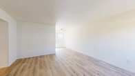 Located at 1233 East Madison Avenue in El Cajon, California, this single-story, 3-bedroom, 1-bathroom home offers a clean, functional layout spread across a comfortable floor plan. The living room is bright and open, featuring light wood-style laminate flooring, neutral white walls, a ceiling fan, and a window that invites natural light into the space. A hallway connects the living area to the private quarters of the home.

The galley-style kitchen is efficiently designed with white shaker cabinetry, white countertops, a double basin sink, and white appliances including a gas range and refrigerator. Light wood flooring continues throughout the kitchen, complementing the crisp, clean aesthetic.

Three carpeted bedrooms provide comfortable retreats, each with neutral tones and windows fitted with vertical blinds that offer outdoor views of surrounding greenery. The primary bedroom is a well-proportioned space with direct access to the hallway.

The single bathroom is neatly appointed with a white vanity, mirrored medicine cabinet, wood-style flooring, and a walk-in shower enclosed with sliding glass doors. A dedicated closet and hallway complete the interior layout, offering practical storage solutions throughout this well-maintained El Cajon residence.