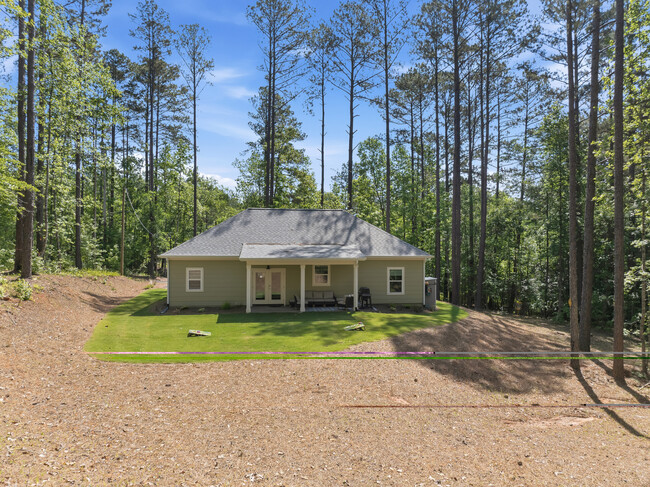 Patio trasero con terraza cubierta, muebles y parrilla. - 183 Crooked Creek Bay Rd