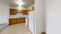 Located at 1220 Estes Park Ct in Rapid City, South Dakota, this 2-bedroom, 1-bathroom single-floor unit offers a straightforward and functional layout across a comfortable footprint. The space is organized to maximize practicality, with each room clearly defined and easily accessible.

The kitchen features warm oak-toned cabinetry extending along two walls, offering ample upper and lower storage. White appliances, including a refrigerator, electric range, and dishwasher, complement the light tile flooring, creating a clean and efficient cooking space.

Both bedrooms are carpeted and bathed in natural light through large windows that frame outdoor greenery and surrounding landscape views. Baseboard heating is present in each room. The primary bedroom includes a window-unit air conditioner and connects to a spacious walk-in closet with built-in shelving and hanging rods. A second closet provides additional storage elsewhere in the unit.

The bathroom features tile flooring, an oak vanity with storage below, and a clean, neutral color palette consistent throughout the unit.

The living room offers a generously proportioned open area with soft carpet and bright, neutral walls, providing a versatile space for various furniture arrangements. Overall, the unit maintains a clean, understated aesthetic throughout.