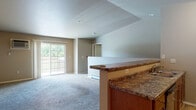 Located at 1705 Cottontail Ln in Reedsburg, Wisconsin, this two-floor residence offers a well-organized layout across two levels, combining functional design with comfortable living spaces. The lower level houses an attached garage with an automatic opener, providing secure, convenient parking and additional storage space on a concrete floor.

The main living level features an open-concept design where the kitchen flows directly into the living area. The kitchen is equipped with warm wood cabinetry, granite-style countertops, stainless steel appliances including a refrigerator, range, and microwave, and durable hardwood-style flooring. A peninsula counter with seating separates the kitchen from the carpeted living area, which includes a ceiling fan and access to a private balcony through sliding glass doors that bring in ample natural light and outdoor views.

A dedicated laundry room accommodates a full-size washer and dryer with built-in wire shelving for storage. The bathroom features a vanity with granite-style countertops, a undermount sink, wood cabinetry, and a large mirror. Bedrooms are carpeted and include walk-in closets with built-in shelving, offering generous storage throughout.