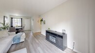 Located at Signal Pointe Circle in Sarasota, Florida, this thoughtfully updated single-floor, 2-bedroom, 1-bathroom home offers a cohesive modern aesthetic defined by a crisp black-and-white palette and light wood-look flooring throughout. The open living room is bright and welcoming, featuring a sliding glass door that invites natural light and provides outdoor access, complemented by a stylish media console with a built-in electric fireplace. The adjacent dining area showcases a painted block accent wall, a round dining table, and natural light from a street-facing window, creating a cozy yet functional space. The kitchen is well-equipped with white shaker cabinetry, white subway tile backsplash, light quartz countertops, and a window that further brightens the workspace. The primary bedroom features the same block wall texture seen in the dining area, offering natural light through a centered window and a spacious closet. The second bedroom is versatile and functional, accommodating a loft bed with a built-in desk — ideal as a child's room or home office. The bathroom continues the clean design language with full white subway tile surrounding the tub/shower combo, black fixtures, and light flooring. Every detail reflects a consistent, modern style throughout this efficiently designed Sarasota home.