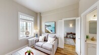 Located at 551 Gibson Ave in the coastal community of Pacific Grove, California, this thoughtfully designed 2-bedroom, 1-bathroom unit offers a compact yet functional single-floor layout. Warm hardwood flooring flows consistently throughout the space, complementing the neutral, light-toned walls that lend the interior a clean and airy feel.

The living room is a welcoming retreat, featuring tall ceilings, a large white-trimmed window with striking coastal views, and ample natural light. The space comfortably accommodates a seating area and media setup, making it well-suited for both relaxing and entertaining.

The primary bedroom is a generously proportioned room for the overall footprint of the unit, featuring a window overlooking the surrounding neighborhood, a classic cast-iron radiator, wall sconce lighting, and crisp white trim details. The second bedroom is a cozy space with its own window, natural light, and room for a bed and small work or dining area.

A dedicated closet provides practical built-in shelving and storage. The bathroom is bright and clean, finished in white with a single-sink vanity, a walk-in glass-door shower, and a separate soaking tub, offering a full suite of amenities.

Overall, the unit presents a cohesive coastal aesthetic, combining functional design with light-filled interiors in one of California's most scenic seaside communities.
