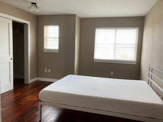 Primary bedroom has plenty of light and a queen bed that comes with the unit and access to bathroom - 2401 SW Brandon St