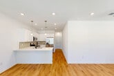 Located at 4400 Chemin Metairie Pkwy in Youngsville, Louisiana, this single-story 2-bedroom, 2-bathroom home offers a clean, modern aesthetic with thoughtful design throughout. Warm hardwood-style flooring flows seamlessly across the entire layout, complementing the bright white walls and recessed lighting that create an airy, welcoming atmosphere.

The open-concept kitchen and living area serves as the heart of the home. The kitchen is outfitted with white shaker-style cabinetry, a subway tile backsplash, quartz countertops, and stainless steel appliances including a range, microwave, and refrigerator. A peninsula with a double sink and matte black faucet provides additional prep space and casual seating. Pendant lighting accents the kitchen, adding a stylish touch.

The primary bedroom is generously sized, featuring a ceiling fan, recessed lighting, and natural light from a window with blinds. It includes access to a spacious walk-in closet with built-in shelving and hanging rods. The en-suite bathroom is finished with white cabinetry, a quartz vanity, a glass-enclosed shower, and matte black fixtures. The second bedroom is equally bright, with a ceiling fan and closet access. A dedicated laundry room includes a full-size washer and dryer. The hallway connects all spaces efficiently, rounding out this well-designed home.