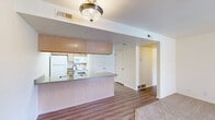 Located at 900 S 1500 E in Clearfield, Utah, this single-floor, 1-bedroom, 1-bathroom residence offers a thoughtfully designed layout that maximizes functionality and comfort. The combined kitchen and living area serves as the heart of the home, featuring durable wood-style flooring, a peninsula-style kitchen with a dual-basin sink, light wood cabinetry, laminate countertops, and white appliances including a refrigerator, stove, and microwave. A sliding glass door in the living area opens to a private balcony, allowing natural light to fill the space and offering pleasant outdoor views. The bedroom is generously sized, featuring plush carpeting, multiple windows fitted with blinds that invite abundant natural light, and access to a dedicated walk-in closet equipped with wire shelving for organized storage. The bathroom includes a full tub-and-shower combination, a wood-toned vanity with a countertop sink, and wood-style flooring that ties the space together cohesively. Throughout the residence, neutral tones and clean finishes create a bright, welcoming ambiance suitable for comfortable everyday living.