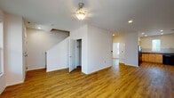Located at 302 S Tenth St in Louisville, KY, this two-floor home offers a well-organized layout with consistent hardwood-style flooring throughout, crisp white walls, and recessed lighting that create a clean, neutral aesthetic. The main level features an open living area anchored by a ceiling fan and staircase with a convenient under-stair closet, providing additional storage. The living space flows into a dedicated kitchen equipped with light wood cabinetry, dark countertops, a double-basin sink, a dishwasher, and a subway tile backsplash, alongside a window that brings in natural light. A compact bathroom on this level includes a tub-shower combination and hardwood-style flooring. A dedicated laundry area houses a full-size, front-loading washer and dryer set with wire shelving above for added utility. The upper level offers generously sized rooms, each with hardwood-style floors and ceiling fans. One room features a closet and a window with exterior views, while a larger room benefits from multiple windows that flood the space with natural light. A full bathroom upstairs includes a vanity with warm wood cabinetry, a tub-shower combination, and coordinating flooring.