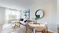 This single-floor residence at 67 Old Amboy Rd presents a thoughtfully designed open-concept layout that seamlessly connects the living, dining, and kitchen areas. Light hardwood-style flooring runs throughout, lending warmth and continuity to the space, while soft neutral wall tones create a bright, airy atmosphere.

The living area is generously proportioned, anchored by large windows dressed with sheer white curtains that invite abundant natural light and outdoor views. Bold abstract artwork provides a striking focal point against the clean walls, complementing the contemporary aesthetic.

The dining area sits adjacent to the living space, featuring a round table and stylish seating that maximizes the open feel. A large round mirror adds dimension to the area. The kitchen features dark wood cabinetry with modern hardware, white quartz countertops, a subway tile backsplash, and stainless steel appliances, including a gas range and French door refrigerator. A breakfast bar with seating bridges the kitchen and dining zone.

The bedrooms offer a tranquil retreat, each with natural light, hardwood-style flooring, and generous closet space. The bathroom is finished with neutral tile flooring, white subway tile surrounding the tub-shower combination, and dark wood cabinetry for ample storage.