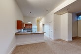 Located at 9607 Dewitt Dr in Silver Spring, MD, this single-floor, 2-bedroom, 2-bathroom residence offers a thoughtfully designed layout with generous living space. The open-concept living, dining, and kitchen area is a standout feature, highlighted by soaring ceilings that amplify the sense of openness. The kitchen is equipped with warm wood cabinetry, laminate countertops, a double sink, a white appliance suite, and pendant lighting above a peninsula breakfast bar that connects seamlessly to the carpeted living and dining area. Both bedrooms are carpeted and well-proportioned, with the primary bedroom offering notable space. The second bedroom features low-set windows that allow natural light to filter in. Three closets throughout the unit provide ample storage. The two bathrooms are identically appointed with accessible features, including grab bars, open under-sink vanities with wood drawer units, large mirrors with overhead lighting, and tiled tub-shower combinations. Hallways connect the rooms efficiently, contributing to a smooth and functional flow. Neutral tones and clean finishes throughout lend the space a calm, livable ambiance suited for everyday comfort.