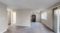 This single-floor, 2-bedroom, 1-bathroom residence offers a functional and well-organized layout with a neutral color palette throughout. The living room is a standout space, featuring durable laminate wood flooring, a ceiling fan, baseboard heating, and dual windows — including a sliding glass door that opens to an outdoor patio area, flooding the room with natural light and providing views of the surrounding greenery.

The kitchen is thoughtfully designed with gray shaker-style cabinetry, granite-look countertops, and black appliances including a refrigerator and dishwasher. Light vinyl flooring and a window add brightness to the space.

Both bedrooms are carpeted and offer a quiet, comfortable atmosphere. The primary bedroom is generously sized and includes a closet with built-in shelving, while the second bedroom benefits from a wide window with horizontal blinds that frame outdoor views. Baseboard heating is present in both rooms.

The bathroom features a long vanity with gray cabinetry and a speckled countertop, a single sink, and a separate toilet and shower area with wood-look flooring. A hallway connects the main living areas to the bedrooms and bathroom, providing a clear and efficient flow throughout the residence.