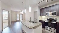 This 590 square foot one-bedroom apartment in Villaggio (unit A1A, 05-5303) offers a blend of comfort and style. The open floor plan maximizes space efficiency, seamlessly connecting the living areas. The gourmet kitchen is a highlight, boasting dark wood cabinetry, stainless steel appliances, and granite countertops with a breakfast bar. The bathroom features a granite-topped vanity and wood-look flooring. The 130 square foot bedroom is carpeted and includes a ceiling fan and large windows for natural light. Throughout the apartment, you'll find modern finishes like track lighting and pendant fixtures. The unit also includes a closet for additional storage. Wood-look flooring in the main living areas adds warmth and durability. This well-designed space is perfect for those seeking a contemporary urban lifestyle in a compact, efficient layout.