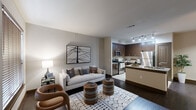 Located at 14700 Woodson Park Drive in Houston, TX, this 2-bedroom, 1-bathroom home offers a smartly designed single-floor layout that balances comfort and modern style. The living room features rich dark hardwood flooring, neutral walls, and natural light filtered through wood-blind windows, creating a warm and inviting atmosphere. The kitchen is a standout space, outfitted with rich dark cabinetry, granite countertops, stainless steel appliances including a refrigerator, microwave, and range, and a peninsula island with a double sink — ideal for both cooking and entertaining. Adjacent to the kitchen, the dining area provides a cozy setting with its own distinct character. Both bedrooms are carpeted and include ceiling fans, wood-blind windows, and generous closet space — the primary bedroom features a walk-in closet with multi-level wire shelving. The bathroom is finished with tile flooring, a dark-framed vanity mirror, and rich espresso cabinetry. Dark-stained interior doors and trim carry a consistent design language throughout the home, lending a cohesive and polished aesthetic from entry to bedroom.