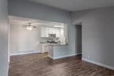 Located at 16945 Del Monte Avenue in Morgan Hill, California, this single-floor residence offers two bedrooms and four bathrooms within a well-organized, efficiently designed layout. The open-concept living and kitchen area serves as the heart of the home, featuring durable wood-look flooring and a ceiling fan overhead. The kitchen is outfitted with white shaker cabinetry, gray countertops, stainless steel appliances including a gas range, microwave, and refrigerator, and a peninsula with a stainless steel sink—ideal for both cooking and casual dining. The living room extends to a sliding glass patio door that brings in natural light and provides outdoor access. Both bedrooms are finished with plush carpeting and feature windows that allow ample natural light; the primary bedroom offers a comfortable, well-proportioned footprint. The four bathrooms are finished with wood-look flooring, white vanities with gray countertops, and clean, modern fixtures—including at least one tub/shower combination. A dedicated laundry area, hallway, and closet round out the functional layout. Baseboard heating is present throughout. The overall aesthetic is clean and contemporary with a neutral color palette.
