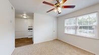 Located at 300 Sulphur Springs Rd in Greenville, SC, this single-floor, one-bedroom, one-bathroom unit offers a practical and efficient layout designed to maximize every square foot of its compact footprint. The living area features soft carpeted flooring, a ceiling fan with built-in lighting, a textured ceiling, and a window with blinds that allows natural light to filter in. It connects seamlessly to the kitchen, which is outfitted with white cabinetry, a white electric range, dishwasher, full-size refrigerator, and a single-basin sink — all set atop wood-look vinyl flooring that extends through the kitchen and entry areas. The bedroom is a well-proportioned private retreat with carpet flooring, a ceiling fan, and a generously sized window offering outdoor views and natural light. Two closets provide ample storage throughout the unit. The bathroom features a full tub-shower combination with white surround, wood-look vinyl flooring, and clean, bright white walls. A dedicated utility room adds practical functionality. The overall aesthetic is clean and neutral, with white walls and consistent finishes throughout.