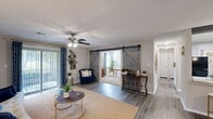 Located in Garden City, Georgia, this single-floor, two-bedroom residence offers a well-designed layout with a comfortable and functional living experience. The open-concept living area features wood-look flooring, a ceiling fan, and a sliding glass door that fills the space with natural light and provides direct access to a private patio. A distinctive pair of sliding barn doors connects the living area to an additional room, adding a charming architectural detail to the interior.

The kitchen is well-appointed with white shaker-style cabinetry, granite-look countertops, a subway tile backsplash, and black appliances. A peninsula with pendant lighting and bar seating doubles as a casual dining space, while an exposed decorative beam adds visual character. A separate dining area with wood-look flooring provides additional space for entertaining.

Both bedrooms are carpeted and include ceiling fans, natural light from windows, and generous closet access — four closets in total throughout the home ensure abundant storage. The bathroom features wood-look flooring, a granite-topped vanity, and a tub-shower combination. A dedicated laundry room with shelving and in-unit washer hookups adds everyday convenience to this thoughtfully designed home.