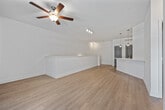 This two-story home in Birmingham, Alabama offers a well-organized layout across two levels. The ground floor houses a private garage with concrete flooring and interior access via a carpeted staircase with white railings, leading up to the main living level. The upper floor encompasses the primary living spaces, including an open-concept dining room, kitchen, and living room. The kitchen is equipped with dark wood cabinetry, white quartz countertops, a subway tile backsplash, and a full suite of stainless steel appliances. Light wood-style flooring flows throughout the main living area, which features a ceiling fan and a glass-panel door that brings in natural light. A dedicated pantry and laundry area add everyday convenience. The bedroom is carpeted and well-sized, offering two closets with gray panel doors and a window overlooking the surrounding neighborhood. The bathroom includes a sliding glass-door walk-in shower, light wood-tone flooring, and a vanity with white countertops and dark cabinetry. With four closets total throughout the home, storage is plentiful. The clean, neutral color palette and modern finishes give the space a fresh, functional aesthetic throughout.