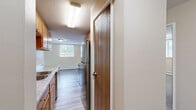 Located at 2240 Skillman Ave E in North St. Paul, Minnesota, this two-bedroom, one-bathroom unit offers a practical and comfortable single-floor layout. The open-concept living and dining area is bright and welcoming, featuring large windows that bring in natural light, light-toned walls, and a seamless transition between plush carpeted living space and easy-care luxury vinyl plank flooring in the kitchen zone. The kitchen is efficiently laid out with warm honey-toned cabinetry, stainless steel refrigerator and range, a built-in microwave, and a peninsula that provides additional counter space and casual dining potential. A hallway connects the main living areas to the two carpeted bedrooms, each offering a comfortable, quiet retreat. Both bedrooms feature sliding-door closets with built-in hanging rods and are served by baseboard heating. Natural light filters through blinds-covered windows in each room. The shared full bathroom features classic white tile with a pink accent border, a tub-shower combination, mosaic tile flooring, a wood-tone vanity, and a well-lit mirror. A hallway provides additional storage access. The overall ambiance is clean, neutral, and move-in ready.