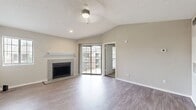 This 530-square-foot apartment offers a thoughtful blend of comfort and functionality. The open-concept living area showcases modern gray wood-look flooring, creating a seamless flow between spaces. A standout feature is the inviting fireplace with a white mantel, adding warmth and character to the room. Large windows and a sliding glass door flood the space with natural light and provide balcony access, expanding the living area outdoors.

The kitchen boasts a fresh, contemporary design with white cabinetry, stainless steel appliances, and a herringbone tile backsplash. A peninsula with a built-in sink doubles as a breakfast bar, optimizing the compact space. The 140-square-foot bedroom features plush carpeting and a closet for storage. The bathroom continues the modern aesthetic with a white vanity, large mirror, and over-toilet storage.

Throughout the apartment, neutral wall colors create a bright, airy atmosphere. Recessed lighting and ceiling fans enhance the overall ambiance. This well-designed space efficiently accommodates all essential living areas, making it an ideal home for those seeking a cozy yet stylish urban dwelling.