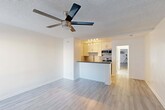 Located at 6555 La Mirada Ave in the heart of Hollywood, Los Angeles, this efficiently designed single-floor unit offers a thoughtfully arranged open-concept layout. The combined kitchen and living area maximizes the available space, featuring light wood-style flooring and a textured ceiling with a ceiling fan that promotes airflow and comfort throughout. A large window allows natural light to brighten the living area, which also includes a wall-mounted AC unit for year-round climate control.

The kitchen stands out with white shaker cabinetry, a decorative tiled backsplash, dark countertops, and a peninsula that doubles as a breakfast bar. Stainless steel appliances — including a gas range, microwave, and sink — complete the functional and modern kitchen setup. Track lighting overhead illuminates the workspace effectively.

The unit includes two bathrooms. One features a clean, all-white walk-in shower stall equipped with grab bars for added accessibility, while the other offers a vanity with white cabinetry, a rich wood-toned countertop, an undermount sink, and a full-length mirrored sliding door that enhances the sense of space. Both bathrooms maintain a bright, clean aesthetic consistent with the rest of the unit.