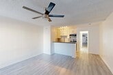 Located at 6555 La Mirada Ave in the heart of Hollywood, Los Angeles, this efficiently designed single-floor unit offers a thoughtfully arranged open-concept layout. The combined kitchen and living area maximizes the available space, featuring light wood-style flooring and a textured ceiling with a ceiling fan that promotes airflow and comfort throughout. A large window allows natural light to brighten the living area, which also includes a wall-mounted AC unit for year-round climate control.

The kitchen stands out with white shaker cabinetry, a decorative tiled backsplash, dark countertops, and a peninsula that doubles as a breakfast bar. Stainless steel appliances — including a gas range, microwave, and sink — complete the functional and modern kitchen setup. Track lighting overhead illuminates the workspace effectively.

The unit includes two bathrooms. One features a clean, all-white walk-in shower stall equipped with grab bars for added accessibility, while the other offers a vanity with white cabinetry, a rich wood-toned countertop, an undermount sink, and a full-length mirrored sliding door that enhances the sense of space. Both bathrooms maintain a bright, clean aesthetic consistent with the rest of the unit.