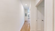 Located at 900 SE Third Ave in Ocala, FL, this one-bedroom, one-bathroom unit offers a thoughtfully designed single-floor layout that maximizes every square foot. The open-concept kitchen and living area serves as the heart of the space, featuring light wood-look flooring, crisp white walls, and a ceiling fan that enhances airflow and comfort. The kitchen is outfitted with white shaker-style cabinetry, granite-look countertops, and a full suite of stainless steel appliances — including a refrigerator, range, microwave, and dishwasher — providing a clean, modern aesthetic. A window in the living area allows natural light to fill the space. A hallway connects the main living area to the private quarters, with an electrical panel conveniently recessed into the wall. The bathroom features white cabinetry with brushed nickel hardware, a granite-topped vanity with an undermount sink, and hardwood-style flooring that continues the cohesive design language. The bedroom offers soft carpeting underfoot and neutral walls, creating a calm and restful retreat. Overall, the unit presents a fresh, move-in-ready environment with consistent modern finishes, efficient use of space, and a clean, neutral palette throughout.