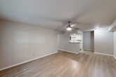 Located in Tomball, TX, this single-story 2-bedroom, 2-bathroom residence offers a well-designed layout with a clean, modern aesthetic throughout. Light wood-look flooring runs continuously through the living areas and bedrooms, complementing the neutral warm-gray wall palette and crisp white trim. The open living room is bright and airy, featuring a ceiling fan and a window that brings in natural light. It connects seamlessly to the kitchen via a pass-through counter, creating an open and functional flow. The kitchen is well-appointed with white shaker-style cabinetry, granite countertops, a marble-look tile backsplash, a stainless steel undermount sink, and a full suite of stainless steel appliances including a range, microwave, refrigerator, and dishwasher. The primary bedroom is generously sized, featuring a ceiling fan and access to a dedicated closet. The second bedroom also includes a ceiling fan and ample space. Both bathrooms offer tub/shower combinations — one with a clean white surround and built-in shelving, and the other with striking marble-look tile surround for an elevated finish. A hallway connects the bedrooms and bathrooms, completing this efficiently planned home.