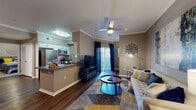 Located at 2100 W Texas St in Fairfield, California, this single-floor residence offers a thoughtfully designed layout with a seamless flow between its primary living spaces. The open-concept living room is anchored by rich hardwood-style flooring, crown molding, and a ceiling fan, creating a polished yet comfortable atmosphere. A sliding glass door floods the space with natural light and provides access to an outdoor area. The kitchen is equipped with stainless steel appliances, including a refrigerator, dishwasher, and microwave, complemented by white cabinetry, dark countertops, and a breakfast bar that connects it to the living area. A dedicated dining nook offers an intimate setting for meals. The two bedrooms feature plush carpeting, large windows with ample natural light, and generous closet access. The bathroom includes a wide vanity with dual sinks, a large mirror, and hardwood-style flooring, offering both functionality and style. Throughout the residence, neutral warm-gray tones create a cohesive and inviting ambiance, making this a comfortable and modern home in the heart of Fairfield.