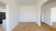 This 420 square foot apartment in Chicago offers a well-designed living space with two bedrooms and one bathroom. The interior showcases a blend of modern finishes and practical features. The living areas and bedrooms are adorned with plush, neutral-toned carpeting, creating a warm and inviting atmosphere. Large windows in the bedrooms allow ample natural light to flood the space, offering views of the surrounding neighborhood.

The kitchen, while compact, is efficiently designed with light wood-look flooring, granite countertops, and updated appliances including a gas stove and black refrigerator. Light blue cabinetry adds a touch of color to the otherwise neutral palette.

The bathroom features a combination of tiled walls and wood-look flooring, with a standard tub-shower combo, pedestal sink, and toilet. The space is functional and maintains a clean, contemporary aesthetic.

The apartment's layout maximizes the use of its 420 square feet, with the primary bedroom measuring 120 square feet. Four hallways connect the various rooms, ensuring easy navigation throughout the space. The white walls throughout the apartment contribute to a sense of openness and brightness, making the compact space feel more expansive. Located at 8100 S Essex Ave in Chicago, this apartment offers a cozy and efficient living solution in an urban setting.