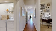 Located at 6355 Peachtree Dunwoody Rd in Sandy Springs, GA, this single-floor residence offers a thoughtfully designed layout that balances functionality and style. A long, well-lit hallway with rich hardwood flooring serves as the central spine of the home, connecting each room with ease and lending an open, airy feel throughout.

The living room is a welcoming space, featuring hardwood floors, a ceiling fan, and generous natural light streaming through large windows dressed with elegant floor-to-ceiling drapes. Adjacent to the living area, the dining space comfortably accommodates a round table and chairs, flowing naturally into the kitchen.

The kitchen is a standout feature, outfitted with rich dark wood cabinetry, granite countertops, a tile backsplash, and stainless steel appliances. A breakfast bar with pendant lighting and bar seating provides additional casual dining options and a modern aesthetic.

The primary suite includes a spacious walk-in closet with built-in shelving and access to a well-appointed en-suite bathroom. The bathroom features a dual-sink vanity with granite counters, a glass-enclosed shower, a soaking tub, and tile flooring. Additional bedrooms include ample closet storage. A utility area with full-size washer and dryer adds convenience to this polished and practical home.
