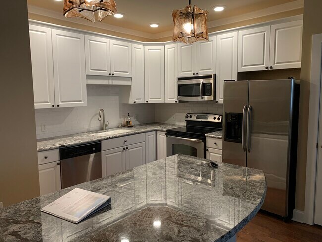 Kitchen with granite countertops, white subway tile backsplash, and stainless appliances - 445 W Blount Ave