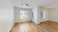 This thoughtfully designed 1-bedroom, 1-bathroom residence offers an efficient and comfortable single-floor layout. Light-toned hardwood-style flooring runs throughout, lending a clean, cohesive aesthetic to the entire space. The open-concept living and dining area is bright and airy, benefiting from multiple windows dressed with horizontal blinds that frame views of surrounding greenery. A track lighting fixture anchors the dining area, adding a modern touch. The kitchen is well-equipped with warm wood cabinetry, granite countertops, a tile backsplash, and a full suite of stainless steel appliances including a French-door refrigerator, gas range, and built-in microwave. A pass-through counter connects the kitchen to the living area, enhancing the open feel. The entry foyer features a flush-mount light fixture and provides convenient access to the kitchen. The bedroom is a calm, neutral retreat with a large window offering natural light and exterior views. The full bathroom is generously sized, showcasing a double-sink vanity with granite countertops, warm wood cabinetry, a large mirror with vanity lighting, and light flooring. A dedicated closet completes the layout, providing practical storage within this well-organized residence.