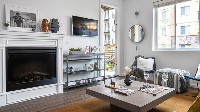 Apartment living room with wood-style flooring, fireplace and balcony. - Griffis Lake Washington