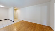 Located at 2009-2011 Haste St in Berkeley, CA, this one-bedroom, one-bathroom unit offers a practical and comfortable layout across a single floor. The living room is a bright, welcoming space featuring warm hardwood flooring and a sliding glass door that floods the room with natural light while providing direct access to an outdoor area with views of surrounding greenery and neighborhood rooftops. The clean white walls create a neutral canvas throughout.

The kitchen is efficiently designed with warm wood cabinetry, dark countertops, and light tile flooring. It is equipped with a full suite of appliances including a range, overhead microwave, and a full-size refrigerator. A window above the sink brings in additional natural light, making the space feel open and functional.

The bedroom is a comfortable, well-proportioned room with hardwood flooring, a wide horizontal window overlooking lush treetops, and a full mirrored sliding closet that enhances the sense of space and light.

The bathroom features light wood-tone tile flooring, a white vanity with ample cabinet storage, and a striking marble-patterned tub and shower surround with a sliding glass enclosure, lending an elegant touch to the room.

A tiled entryway hallway connects the spaces cleanly, completing this well-organized and move-in-ready Berkeley home.