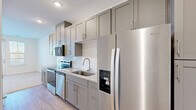 Located at 340 W Third St SW in Rome, Georgia, this efficiently designed single-floor unit offers a thoughtfully organized layout that maximizes every square foot. The kitchen is a standout feature, showcasing floor-to-ceiling gray shaker cabinetry, granite-look countertops, a white subway tile backsplash, and a full suite of stainless steel appliances including a range, dishwasher, microwave, and a refrigerator with an ice and water dispenser. Light wood-tone flooring runs through the kitchen and connecting areas, lending warmth to the space. The living and sleeping areas are carpeted in a neutral tone, creating a soft, comfortable atmosphere. Large windows fitted with white blinds allow ample natural light to filter in, and a glass-panel door opens directly onto a private balcony, extending the living space outdoors. The bathroom is clean and functional, featuring a granite-topped vanity with gray cabinetry, wood-look flooring, and a full shower-tub combination with brushed nickel fixtures. Additional conveniences include a dedicated closet with double doors, an in-unit laundry area, and a utility room, ensuring practical storage and everyday functionality throughout this well-finished unit.
