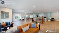Located at 5440 Atlantic Springs Rd in Raleigh, NC, this single-floor space offers a thoughtfully designed open-concept layout that seamlessly integrates a living room, kitchen, and dining area. Light oak hardwood-style flooring flows continuously throughout, lending warmth and visual cohesion to the entire floor plan.

The living area is generously proportioned, featuring multiple large windows that frame views of the surrounding greenery and fill the space with abundant natural light. Recessed lighting complements the bright atmosphere, while neutral white walls provide a clean, modern backdrop. The room comfortably accommodates multiple seating arrangements, making it well-suited for both relaxed gatherings and social events.

The kitchen is a standout feature, centered around a substantial white waterfall island with bar seating. Grey shaker-style cabinetry, white subway tile backsplash, stainless steel appliances, and a teal accent wall add character and a contemporary edge to the space.

The dining area, positioned adjacent to the kitchen, benefits from oversized windows overlooking a wooded outdoor setting, creating an airy, nature-connected atmosphere. A glass-paneled door provides direct exterior access. The overall ambiance is clean, bright, and modern, making this a highly functional and inviting communal space.
