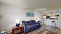 Located at 2975 Coast Dr in Indianapolis, IN, this one-bedroom, one-bathroom residence offers a well-organized single-floor layout that maximizes every square foot. A welcoming entry hallway with a bifold closet leads into the open-concept living area, where durable hardwood-style flooring flows throughout. The living room provides generous space for seating and entertainment, benefiting from natural light streaming through a window dressed with bold curtains. The kitchen is positioned adjacent to the living area, separated by a pass-through breakfast bar that doubles as a casual dining spot. It features upper cabinetry with under-cabinet lighting, a full suite of black appliances including a range and refrigerator, and ample counter space. The bedroom is a comfortable retreat finished with plush carpeting, two windows that invite natural light, and a textured ceiling. A set of bifold closet doors provides practical storage. The full bathroom includes a tiled tub-shower combination, a toilet, and wood-style flooring. Throughout the unit, white walls and a neutral palette create a clean, bright ambiance, while the efficient layout ensures a functional and cohesive living experience.