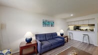 Located at 2975 Coast Dr in Indianapolis, IN, this one-bedroom, one-bathroom residence offers a well-organized single-floor layout that maximizes every square foot. A welcoming entry hallway with a bifold closet leads into the open-concept living area, where durable hardwood-style flooring flows throughout. The living room provides generous space for seating and entertainment, benefiting from natural light streaming through a window dressed with bold curtains. The kitchen is positioned adjacent to the living area, separated by a pass-through breakfast bar that doubles as a casual dining spot. It features upper cabinetry with under-cabinet lighting, a full suite of black appliances including a range and refrigerator, and ample counter space. The bedroom is a comfortable retreat finished with plush carpeting, two windows that invite natural light, and a textured ceiling. A set of bifold closet doors provides practical storage. The full bathroom includes a tiled tub-shower combination, a toilet, and wood-style flooring. Throughout the unit, white walls and a neutral palette create a clean, bright ambiance, while the efficient layout ensures a functional and cohesive living experience.