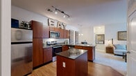 Located at 90 Molina Way in Saint Charles, Missouri, this single-story, three-bedroom, two-bathroom home offers a thoughtfully arranged floor plan that maximizes every square foot. The open-concept kitchen is a standout feature, showcasing rich wood cabinetry, dark granite countertops, stainless steel appliances including a range, microwave, and refrigerator, and a peninsula with a double sink that opens toward the main living area. Hardwood-style flooring runs throughout the kitchen, transitioning to plush carpet in the living and bedroom areas. The living room is bright and welcoming, benefiting from large sliding glass doors that allow natural light to fill the space and provide views to the outdoors. The primary bedroom offers a comfortable footprint with soft carpet, a sliding double-door closet, and a calm, neutral palette. Additional bedrooms are similarly appointed with carpet and generous wall space. A walk-in closet with built-in shelving provides ample storage. The two bathrooms differ in configuration — one features a full tub-shower combination with tile flooring and a wood-toned vanity, while the second includes a framed glass-door shower stall. Together, these spaces create a functional and cohesive home well-suited for everyday living.