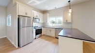 Located on Edmonson Avenue in Monticello, Minnesota, this single-floor, one-bedroom, one-bathroom unit offers a well-organized layout with modern finishes throughout. Light wood-style flooring flows through the main living areas, creating a clean and cohesive aesthetic.

The kitchen is a standout feature, showcasing white shaker-style cabinetry, dark countertops, a classic subway tile backsplash, and a full suite of stainless steel appliances including a refrigerator, range, microwave, and dishwasher. A peninsula with pendant lighting provides additional counter space and separates the kitchen from the living area, which receives natural light through a large window.

The bedroom is carpeted for comfort and features its own window with neighborhood views, along with access to a generously sized walk-in closet outfitted with wire shelving on multiple walls. The full bathroom includes a white vanity with dark hardware, a large mirror, and a tub/shower combination with a curved curtain rod.

Completing the unit is a dedicated laundry room equipped with a full-size washer and dryer and additional wire shelving for storage. Neutral wall tones and consistent black hardware accents tie the space together, offering a clean and modern living environment.