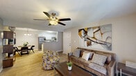 This single-story residence in Jackson, Mississippi offers a thoughtfully designed layout across two bedrooms and two bathrooms. The living room serves as the central gathering space, finished with wood-look luxury vinyl flooring, a ceiling fan with light kit, and a textured ceiling. French doors open from the living area to an outdoor space, allowing natural light to flow freely into the room. The open-plan arrangement connects the living room directly to a dedicated dining area, which features a pendant chandelier fixture overhead, creating an intimate setting for meals.

The kitchen is equipped with white cabinetry, speckled laminate countertops, a double stainless steel sink with a brushed gold faucet, and a dishwasher. A pass-through counter connects the kitchen to the adjacent living and dining areas, enhancing the sense of openness. Both bedrooms are carpeted and include windows with blinds, offering natural light and closet access. The two bathrooms are finished with tile flooring, shower/tub combinations, and clean neutral walls. Throughout the unit, a warm, neutral color palette ties the spaces together cohesively.