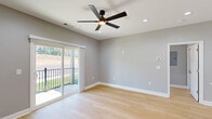 Located in Toccoa, GA, this thoughtfully designed single-story residence offers a modern aesthetic with clean lines and quality finishes throughout. The open-concept kitchen and living area serves as the heart of the home, featuring sleek white cabinetry extending to the ceiling, stainless steel appliances, and a generous quartz-topped island with an undermount sink — ideal for both everyday living and entertaining. Light hardwood flooring flows seamlessly throughout the entire space, enhancing the bright, cohesive feel. The spacious primary bedroom includes a ceiling fan, recessed lighting, and a sliding glass door that opens to an outdoor balcony with greenery views. A second bedroom offers a large window with natural light, a ceiling fan, and a built-in closet. Two well-appointed bathrooms feature white quartz countertops, white cabinetry with matte black hardware, and large mirrors, lending a crisp, contemporary finish. One bathroom includes a window for added ventilation and light. Neutral gray walls, white trim, and recessed lighting are consistent throughout, creating a clean, modern ambiance. A hallway with a pendant light connects the living spaces to the bedroom wing, completing this efficiently designed and move-in-ready home.