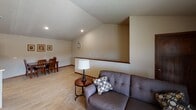 This single-floor residence offers a thoughtfully designed layout that balances comfort and functionality. The living room serves as the central gathering space, featuring vaulted ceilings, recessed lighting, and light hardwood-style flooring that extends toward the dining area. A sliding glass door provides access to an outdoor area, allowing natural light to fill the space. The open layout creates a seamless connection between the living and dining areas.

The kitchen is well-equipped with rich cherry-toned cabinetry, granite-look countertops, and stainless steel appliances, including a refrigerator and electric range. Light hardwood-style flooring continues throughout, contributing to a cohesive feel.

Two bedrooms offer comfortable retreats, each finished with plush carpeting and ceiling fans. The primary bedroom features a window for natural light, while both rooms provide ample space for furnishings.

Two bathrooms mirror each other in design, featuring granite-look vanity countertops, white cabinetry, and patterned tile flooring. Each bathroom includes a shower with a curtain enclosure. A dedicated laundry room houses a full-sized front-loading washer and dryer, adding convenience to daily living. Neutral tones and textured ceilings throughout lend the space a clean, understated aesthetic.
