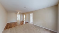 This single-floor residence offers a practical and comfortable layout with a clean, neutral aesthetic throughout. The main living area is generously sized, featuring a combination of warm hardwood flooring and plush carpeting, with beige-toned walls and a ceiling fan providing both style and airflow. A front entry room welcomes natural light through a window fitted with blinds, complemented by a classic six-panel door.

The kitchen is well-appointed with white cabinetry, speckled laminate countertops, and a full suite of appliances including a coil-top electric range, dishwasher, and refrigerator. Hardwood flooring extends through this area, adding warmth and easy maintenance.

The bedroom is a comfortable retreat with soft carpeting, a ceiling fan, and notable storage provided by a walk-in closet. An additional door leads to a connected space, enhancing the room's functionality.

The bathroom is neatly finished with hardwood flooring, a single-sink vanity topped with speckled counters, white upper cabinetry, and a tub-shower combination with tile surround. An additional vanity area with ample cabinet storage is accessible nearby. Throughout, white trim and consistent finishes tie the space together in a cohesive, move-in ready presentation.
