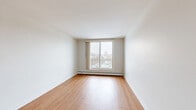 Located at 91 Front Ave W in Brockville, Ontario, this 2-bedroom, 1-bathroom unit offers a practical and well-organized layout across a single floor. Warm hardwood-style flooring flows consistently throughout the living spaces, lending a cohesive and inviting feel to the interior.

The living room is a generously sized area featuring a ceiling fan with light fixture and neutral white walls that create a clean, open atmosphere. A large window allows natural light to fill the room, offering views of the surrounding neighbourhood.

The kitchen is efficiently designed in an L-shaped layout with white shaker-style cabinetry, light-toned countertops, and white appliances including an electric range, refrigerator, and dishwasher. Under-cabinet lighting and a double sink add to the kitchen's functionality.

Both bedrooms are bright and comfortably proportioned, each featuring hardwood-style flooring, baseboard heating, and windows with natural light. The primary bedroom offers a spacious feel, while the second bedroom provides a versatile space suitable for various uses.

The bathroom is finished with full-height beige tile surrounding a soaker tub and shower combination, complemented by chrome fixtures and a safety grab bar. The overall design of the unit is clean, neutral, and move-in ready.
