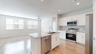 This well-designed 2-bedroom, 2-bathroom residence spans a single floor and offers a bright, contemporary living experience through a clean, modern aesthetic. Light wood-style flooring flows consistently throughout the space, lending warmth and visual continuity across every room.

The open-concept kitchen serves as the functional heart of the home, anchored by a central island with granite countertops, an undermount sink, and a stainless steel dishwasher. White shaker-style cabinetry lines the walls alongside a full suite of stainless steel appliances, including a range, microwave, and refrigerator. The kitchen opens seamlessly into the living room, which is filled with natural light from multiple windows and features a ceiling fan overhead.

The primary bedroom is generously sized, offering a comfortable and private retreat, while the second bedroom includes its own ceiling fan and a window with natural light. Both bedrooms are accompanied by dedicated closets outfitted with wire shelving systems for organized storage. The bathrooms are finished with granite-topped white vanities and wood-look flooring; one bathroom features a soaking tub with marble-style tile surround. A connecting hallway ties the layout together efficiently, completing a thoughtfully arranged and move-in-ready home.